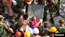 Rescue workers rescue a woman from the rubble of the Rana Plaza building 17 days after the building collapsed in Savar, Bangladesh, May 10, 2013.