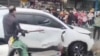 A man breaks a car's window following a vehicle collision outside a primary school in Changde, Hunan province, China in this screengrab obtained from social media video released November 19, 2024. Local authorities have not released details. Social Media/via REUTERS