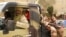 Tuareg fighters from the Movement for the Liberation of Azawad sit in their vehicle in a market in Timbuktu, Mali, April 14, 2012.