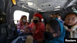 Korban gempa yang diangkat dari Distrik Sindhupalchok duduk dalam helikopter militer menuju Kathmandu, Nepal (3/5). (Reuters/Navesh Chitrakar)