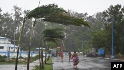 Penduduk berjalan ke tempat perlindungan setelah Topan Yaas menuju pantai timur India, Teluk Benggala, di Digha sekitar 190 km dari Kolkata pada 26 Mei 2021. (Foto: AFP/Dibyangshu Sarkar)