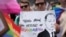 FILE - Participants in the Brooklyn Pride Parade hold a sign that reads, "Putin is afraid of rainbows," May 19, 2024.