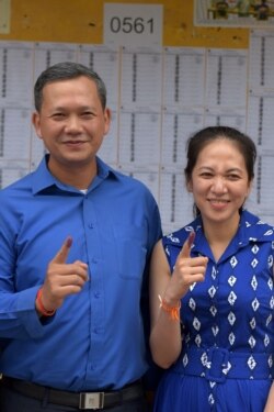 FILE - Son of Cambodian Prime Minister Hun Sen, Hun Manet (L), and his wife Pich Chanmoy show their inked fingers after casting their votes in general elections in Phnom Penh, Cambodia, July 29, 2018.