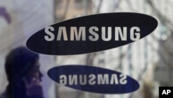 ຊາຍ​ຄົນ​ນຶ່ງ​ຍ່າງ​ຜ່ານ ປ້າຍ​ຂອງ​ບໍລິ​ສັດ Samsung Electronics ​ຢູ່ສູນກາງ​ໃຫຍ່ ​ໃນ​ນະຄ​ອນຫຼວງໂຊ​ລ, ​ເກົາຫຼີ​ໃຕ້.