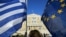 A woman waves a Greek national flag and a European Union flag during a rally outside the Parliament, calling on the government to clinch a deal with its international creditors and secure Greece's future in the Eurozone, in Athens, Greece, June 18, 2015.