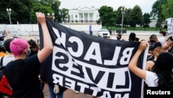 Manifestantes sostienen una bandera que dice "Las vidas negras importan", en el parque Lafayette frente a la Casa Blanca en Washington DC, el 22 de junio de 2020.