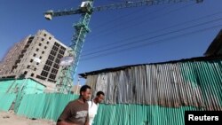 People walk past office blocks under construction in Ethiopia's capital Addis Ababa, January 27, 2010.