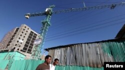 FILE - People walk past office blocks under construction in Ethiopia's capital, Addis Ababa, Jan. 27, 2010. 