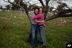 FILE - Anat Katz and her daughter Liat Katz stand among anemone blooming in Re'im, southern Israel, February 12, 2024, at the site of a cross-border attack by Hamas on the Nova music festival where hundreds of revelers were killed and kidnapped into the Gaza Strip.