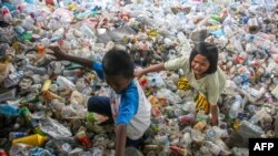 Anak-anak bermain di tumpukan sampah plastik yang dikumpulkan untuk didaur ulang di Makassar. (Foto: AFP)