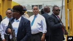 Agentes de seguridad armados escoltan al primer ministro haitiano Garry Conille mientras visita el Hospital General en Puerto Príncipe, Haití, martes 9 de julio de 2024.