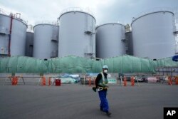 Tangki-tangki penyimpan air radioaktif yang diolah setelah digunakan untuk mendinginkan bahan bakar cair di PLTN Fukushima Daiichi, dijalankan oleh Tokyo Electric Power Company Holdings (TEPCO), di kota Okuma, timur laut Jepang, pada 3 Maret 2022. (Foto : AP)