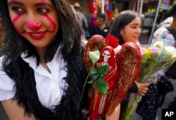 Una creyente sostiene una estatua de "La Santa Muerte", en el barrio de Tepito de la Ciudad de México, el martes 1 de noviembre de 2022.