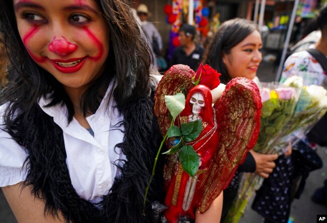 Una creyente sostiene una estatua de "La Santa Muerte", en el barrio de Tepito de la Ciudad de México, el martes 1 de noviembre de 2022.