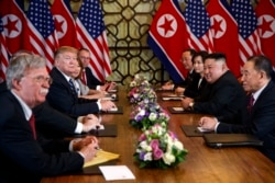 FILE - U.S. President Donald Trump speaks during a meeting with North Korean leader Kim Jong Un, in Hanoi, Vietnam, February 28, 2019. At left is then-National Security Adviser John Bolton.