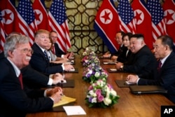 FILE - President Donald Trump speaks during a meeting with North Korean leader Kim Jong Un, in Hanoi, Vietnam, Feb. 28, 2019. At left is then-National Security Adviser John Bolton.