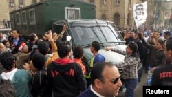 Protesters attack a police vehicle driving by an anti-government protest in Cairo, Feb. 22, 2013.