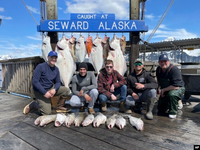 Captain John Moline, right, poses for a photo with others during the annual ASYMCA Alaska Combat Fishing Tournament on May 25, 2022, in Seward, Alaska. The tournament, which began in 2007 and now involves more than 300 soldiers, includes a day of deep-water fishing followed by a celebratory banquet with prizes for the largest catch, smallest catch and soldier who got the sickest. (Armed Services YMCA via AP)