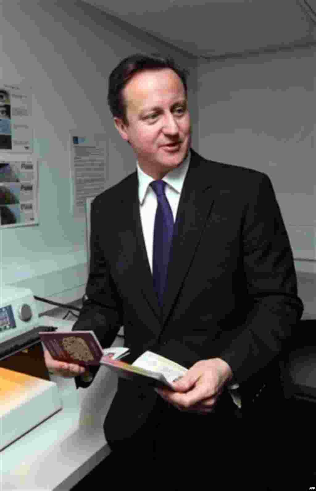 British Prime Minister David Cameron and Home Secretary Theresa May, unseen, visit the UK Border Agency staff at Terminal 5 of Heathrow Airport, London where they were shown differences between fake and real passports Tuesday Nov. 23, 2010. Britain's Home