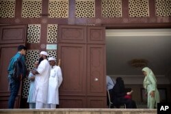 Orang-orang berdiri di pintu masuk Masjid Kowloon di Hong Kong, Senin, 21 Oktober 2019. (Foto: AP)