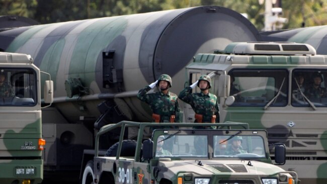 FILE PHOTO: PLA soldiers salute in front of nuclear-capable missiles during a parade in Beijing.