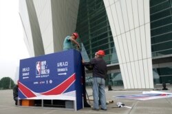 Workers dismantle signage for an NBA fan event that was scheduled to be held at the Shanghai Oriental Sports Center in Shanghai, China, Oct. 8, 2019.