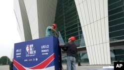 Workers dismantle signage for an NBA fan event that was scheduled to be held at the Shanghai Oriental Sports Center in Shanghai, China, Oct. 8, 2019.