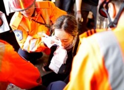 An injured young female medic receives medical assistance after being hit by a pellet round in the right eye during a demonstration in Tsim Sha Tsui neighbourhood in Hong Kong, Aug. 11, 2019.