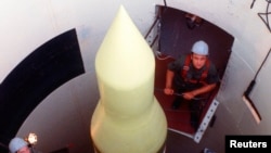 Des techniciens effectuant une vérification d'un missile balistique intercontinental LGM-30F Minuteman III à la base aérienne de Whiteman, dans le Missouri, 1er janvier 1980.