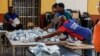 Polling station officials arrange marked ballots before proceeding to the counting at a voting station in Windhoek, Namibia, on December 1, 2024, during extended voting following the country's general election.