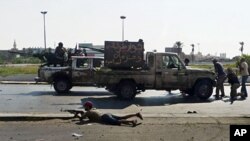 Libyan rebel fighters return fire during an attack by pro-Gadhafi forces after rebels seized a Gadhafi army women's officer training center in Tripoli August 22, 2011