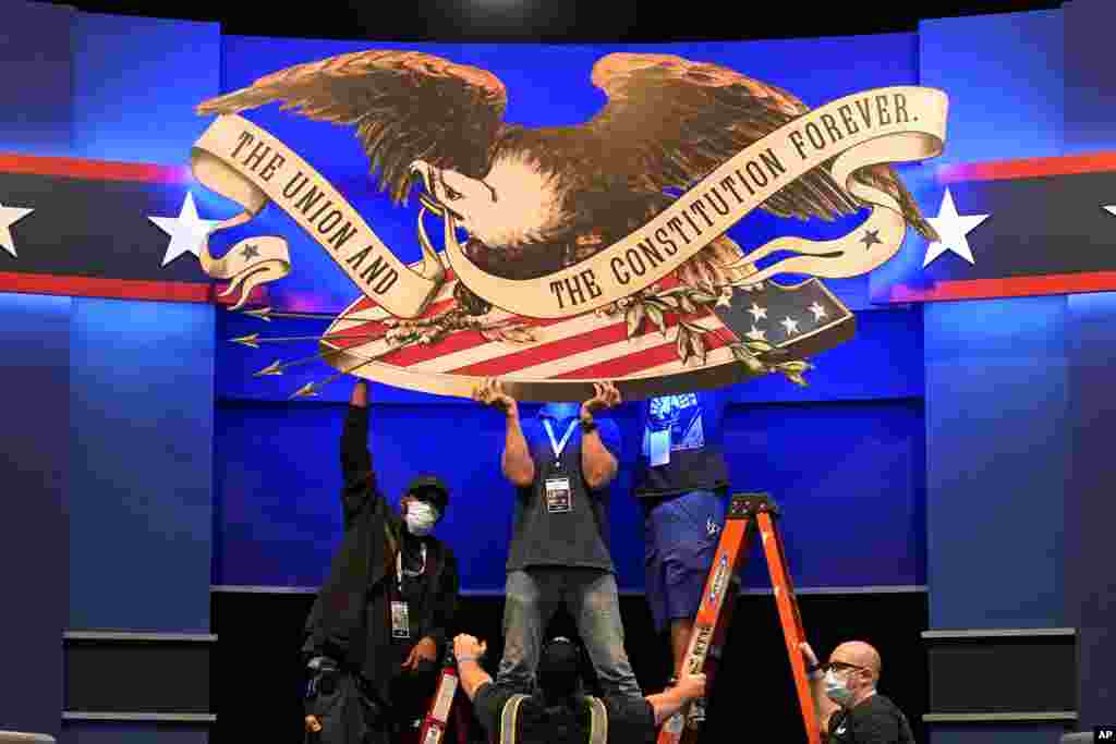 Workers adjust signage as preparations take place for the first Presidential debate in the Sheila and Eric Samson Pavilion, Sept. 28, 2020, in Cleveland,Ohio.