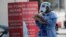 A health care worker carries a stack of clipboards at a COVID-19 testing site sponsored by Community Heath of South Florida at the Martin Luther King, Jr. Clinica Campesina Health Center, during the coronavirus pandemic, July 6, 2020.
