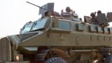 Soldiers from the Uganda People's Defense Force (UPDF) drive in an armored vehicle through the streets of Bor, Jonglei State, on Jan. 19, 2014.