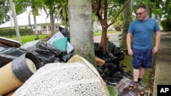 Scott Joyner pored oštećenh predmeta koje je uklonio iz svoje garaže nakon poplave uzrokovane uraganom Helene, u utorak, 8. oktobra 2024., u Punta Gordi, Florida, (AP Photo/Marta Lavandier)