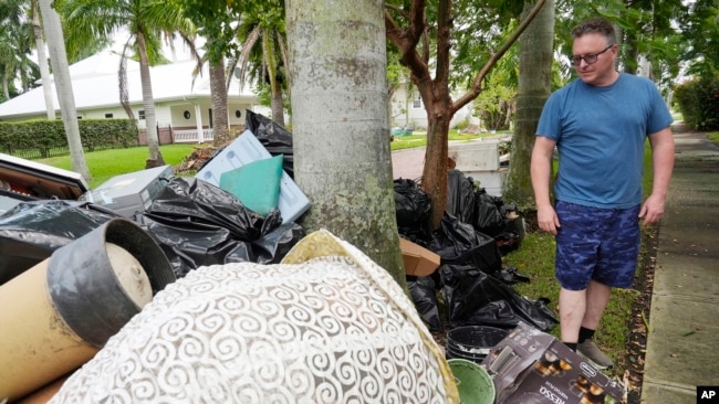 Scott Joyner pored oštećenh predmeta koje je uklonio iz svoje garaže nakon poplave uzrokovane uraganom Helene, u utorak, 8. oktobra 2024., u Punta Gordi, Florida, (AP Photo/Marta Lavandier)