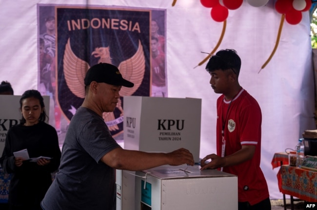 Warga berpartisipasi dalam Pilkada serentak di sebuah tempat pemungutan suara di Surabaya, 27 November 2024. (JUNI KRISWANTO / AFP)