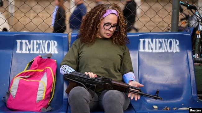 Una simpatizante del gobernante Nicolás Maduro chequea su fusil de asalto en las cercanías del Palacio de Miraflores, en Caracas, el 7 de enero de 2025.