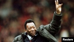 FILE - Brazilian soccer legend Pele greets the crowd at the Manchester United versus Liverpool match during the half time interval in Manchester, Britain, April 10, 1998. 