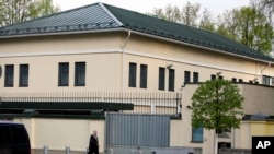 FILE - A man walks past the U.S. Embassy in Minsk, Belarus, May 1, 2008.