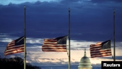 Con el Capitolio de EEUU a la distancia, las banderas ondean a media asta en el Monumento a Washington en el National Mall luego de la muerte del expresidente estadounidense Jimmy Carter, en Washington, EEUU, el 30 de diciembre de 2024.