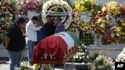 Family members of the slain mayor of Temixco, Gisela Mota, mourn next to her casket, during a ceremony in her honor, at the mayor's office building of Temixco, Mexico, Jan. 3, 2016.