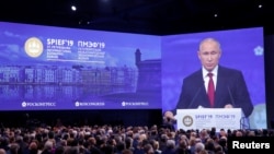 Participants listen to Russian President Vladimir Putin as he delivers a speech during a session of the St. Petersburg International Economic Forum (SPIEF), Russia, June 7, 2019.