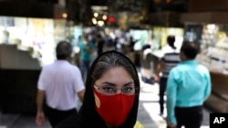 Reyhane Rajaei wearing a protective face mask to help prevent the spread of the coronavirus speaks with The Associated Press at a gold market of Tehran's Grand Bazaar, Iran, Wednesday, July 22, 2020. "My own grandmother died from the new coronavirus…