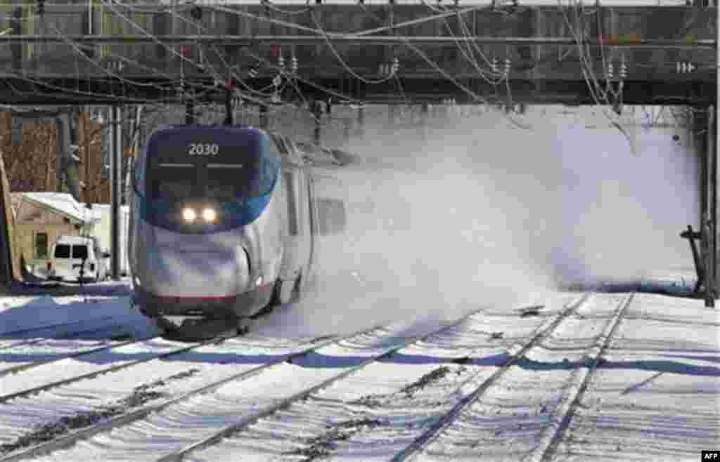 An Amtrak Acela train blows snow as it passes through the Princeton Junction station Tuesday, Dec. 28, 2010, in West Windsor, N.J. The weekend storm has disrupted train schedules. (AP Photo/Mel Evans)