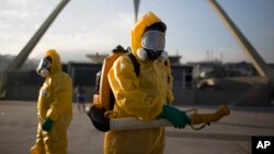 FILE - A health worker stands in the Sambadrome spraying insecticide to combat the Aedes aegypti mosquito that transmits the Zika virus in Rio de Janeiro, Brazil, Jan. 26, 2016. 