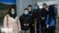 FILE - Chinese travelers wearing face masks to protest against the coronavirus undergo a health screening upon arrival at an Iranian airport in this undated photo published by IRNA on Jan. 30, 2020 (Credit: IRNA)