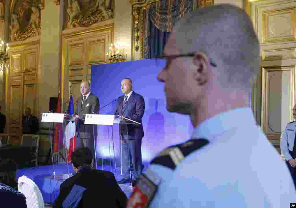 French Foreign Affairs Minister Laurent Fabius (left) and his Turkish counterpart Mevlut Cavusoglu attend a press conference stating concerns that the Islamic State is gaining control of Kobani in Syria, in Paris, Oct. 10 , 2014. 