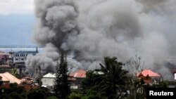 Asap membumbung dari kawasan hunian di Kota Marawi pada saat pertempuran antara tentara pemerintah dan kelompok militan Maute di selatan Filipina, 27 Mei 2017.