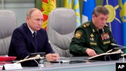 El presidente ruso Vladimir Putin y el jefe de Estado Mayor de Rusia, Valery Gerasimov, supervisan el lanzamiento de prueba del misil hipersónico Avangard, en Moscú, el miércoles 26 de diciembre de 2018.